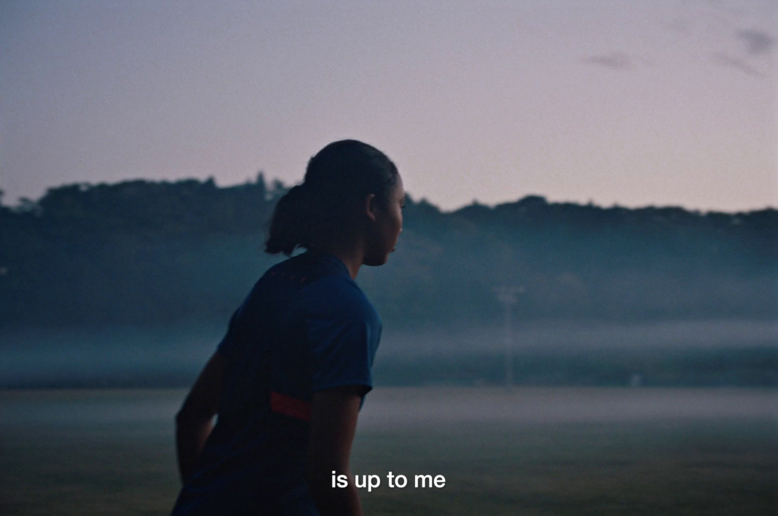 a girl standing in a field with a frisbee in her hand