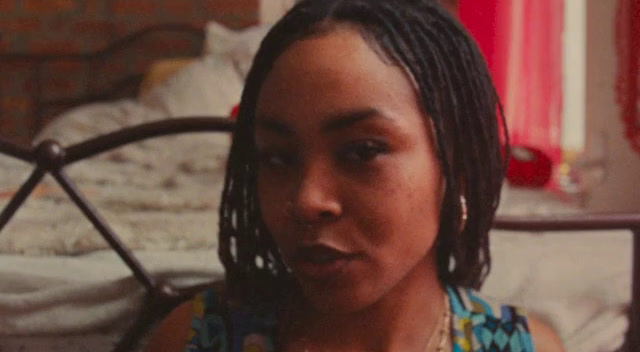 a woman with dreadlocks sitting on a bed