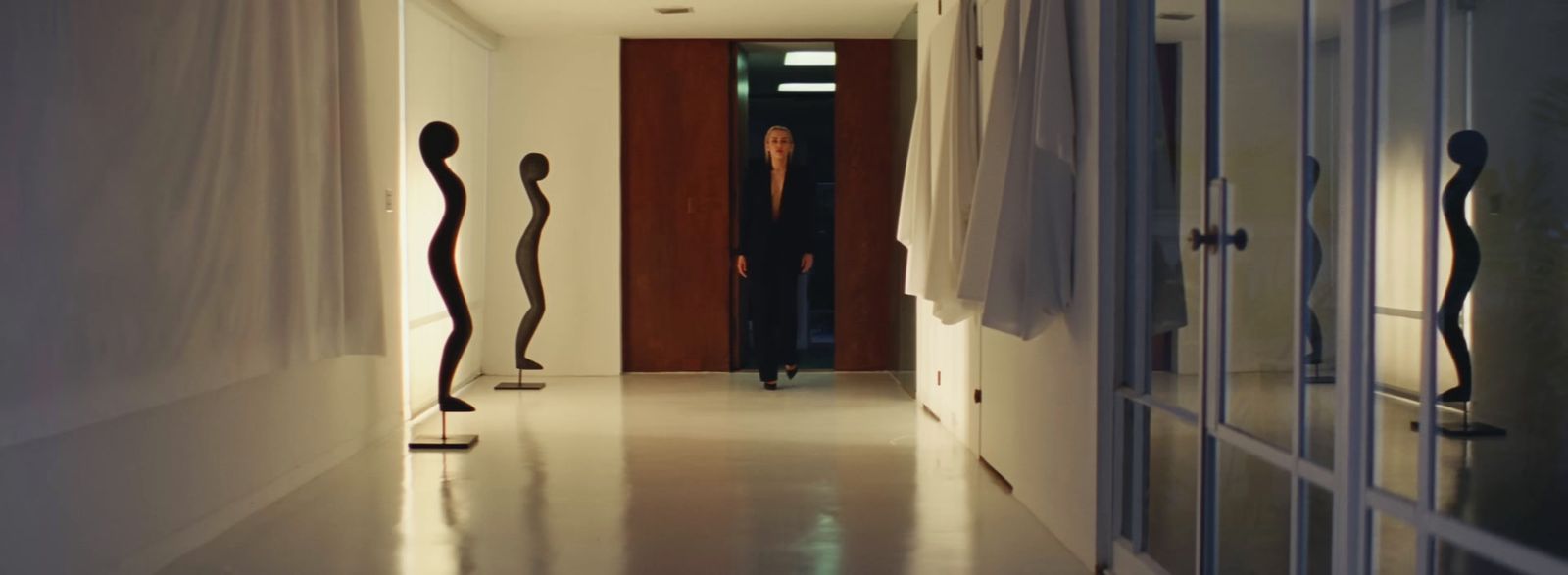 a woman is walking down the hallway of a house