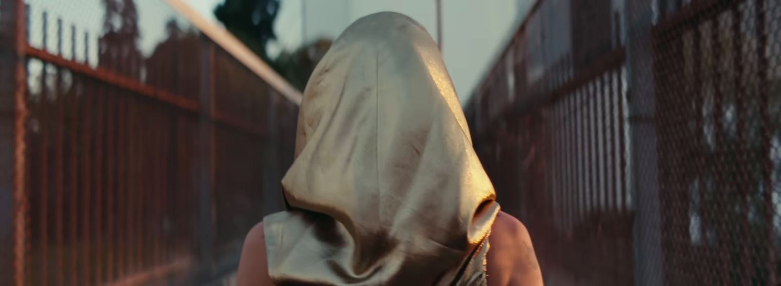 a woman in a hooded cloak walking down a street