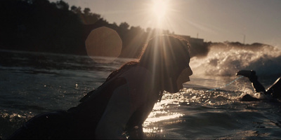 a couple of people riding surfboards on top of a body of water