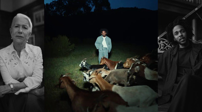 a black and white photo of a woman standing in front of a group of cows