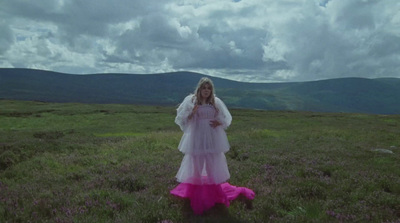 a woman in a white dress standing in a field