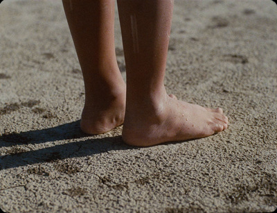 a close up of a person's bare feet in the sand