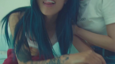 a woman with blue hair and a white shirt