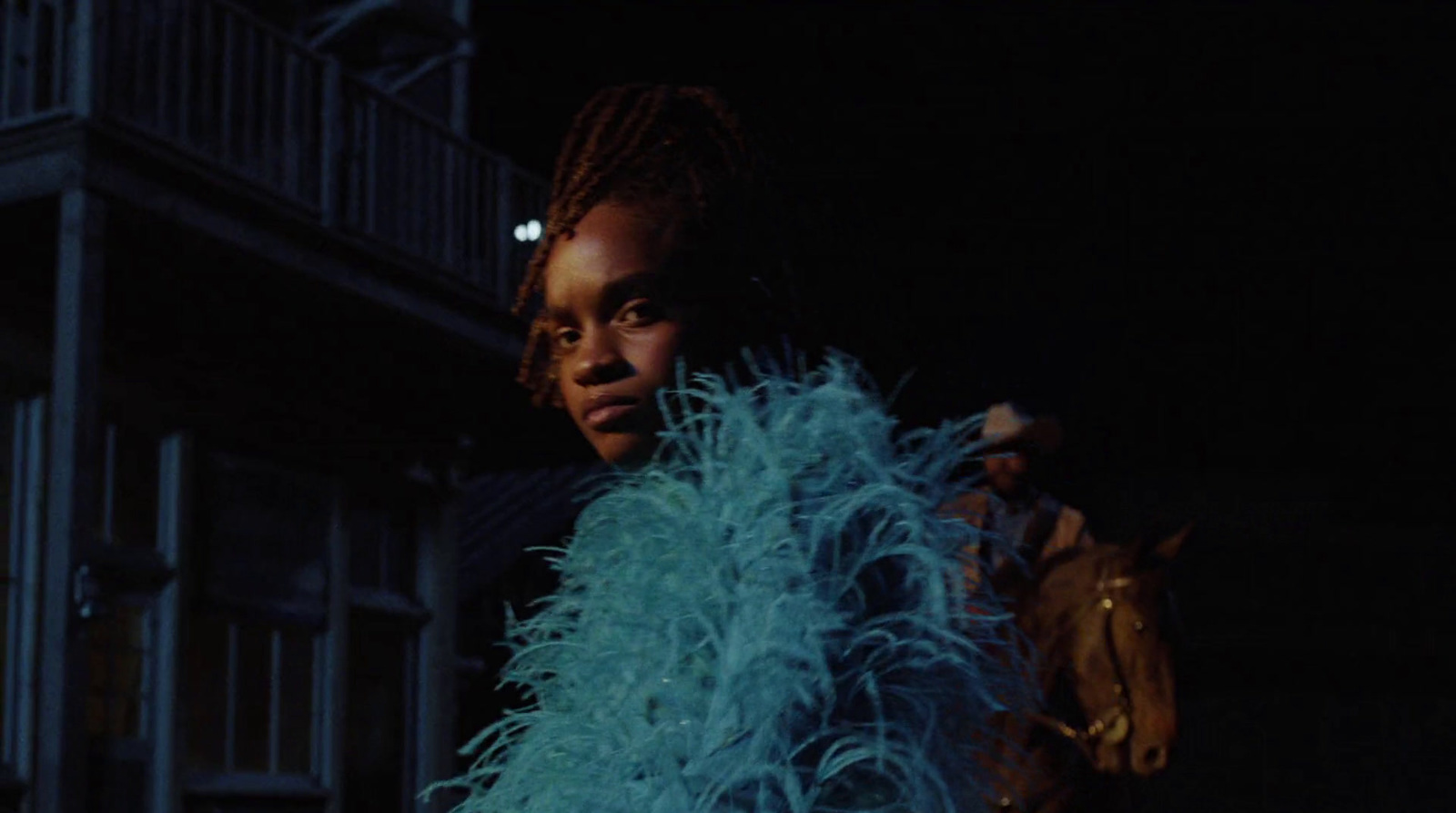 a woman with dreadlocks standing in front of a building