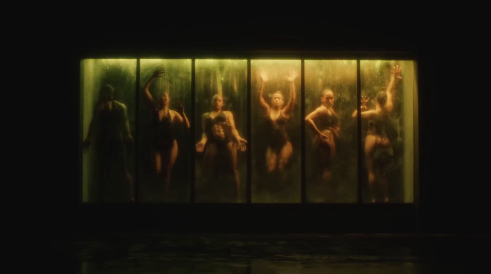 a group of naked women standing in front of a wall