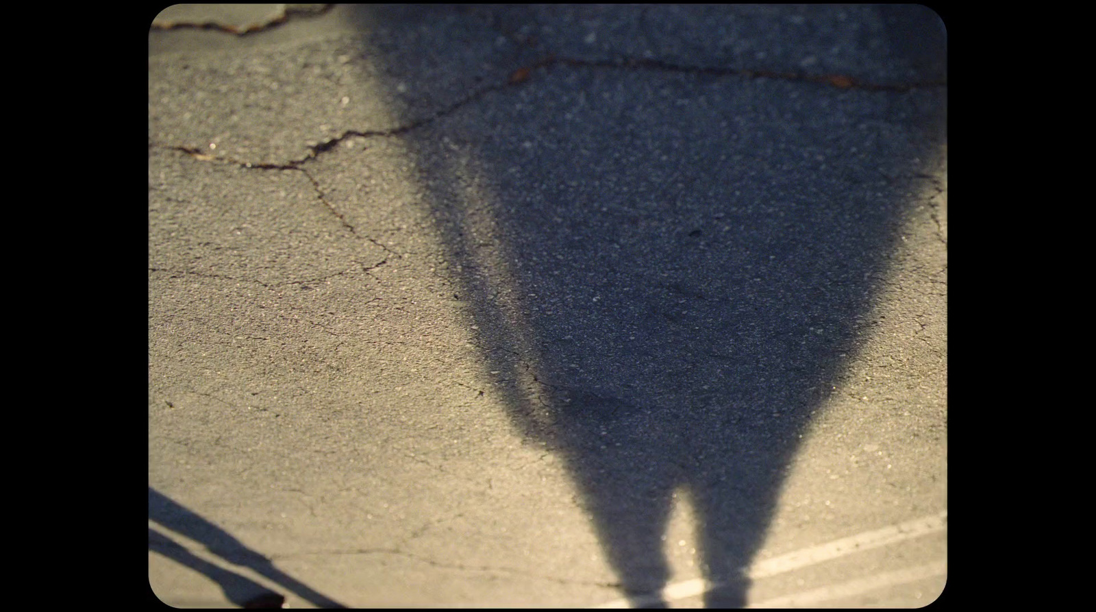 a shadow of a person standing on a sidewalk