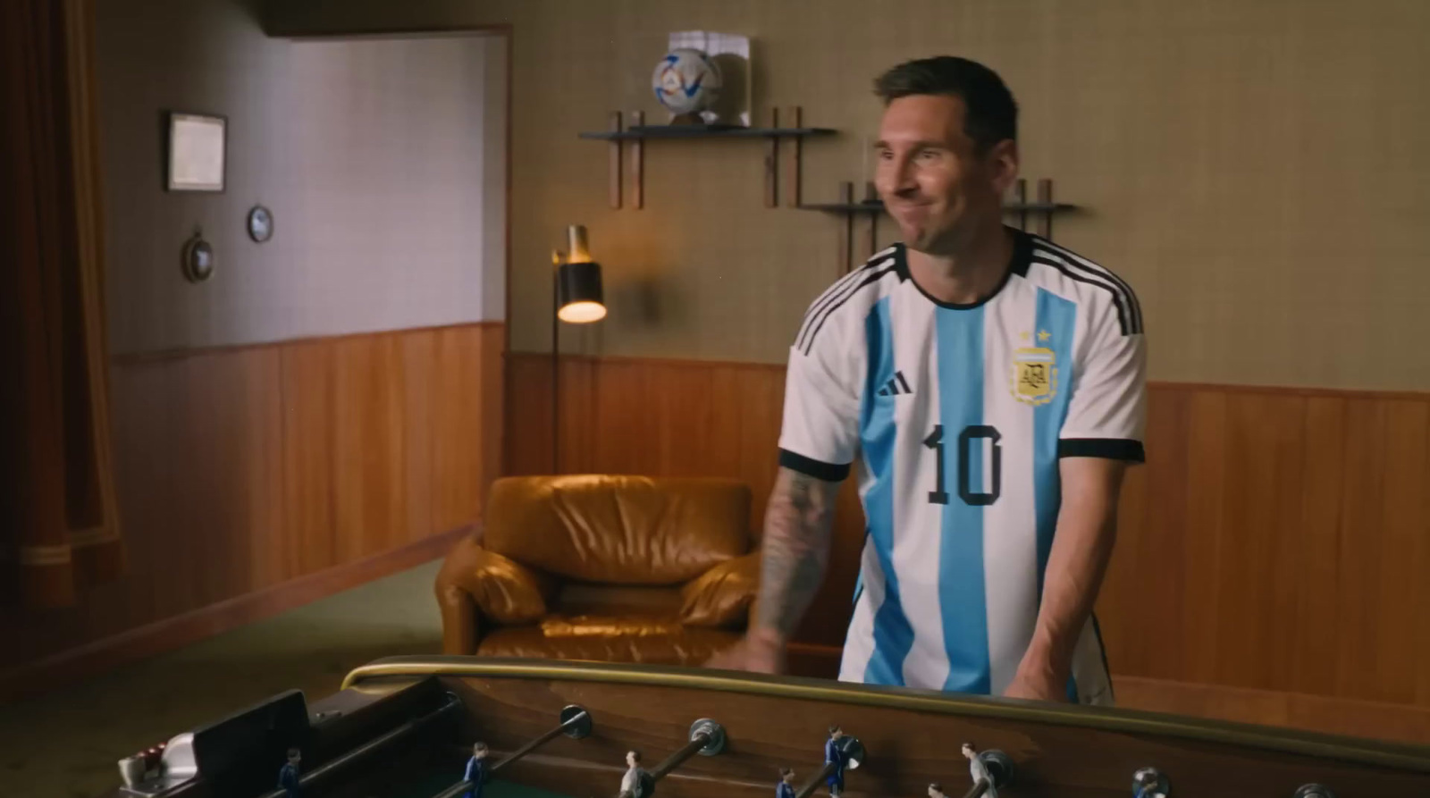 a man standing next to a table with a soccer ball on it