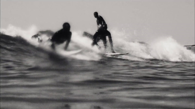 a couple of people riding surfboards on a wave