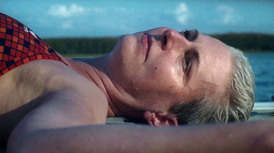 a man laying on the beach with his eyes closed