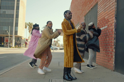 a group of people standing next to a brick building