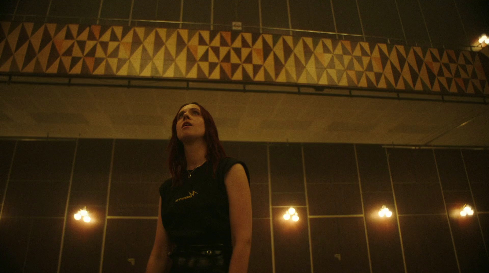 a woman standing in front of a tiled wall