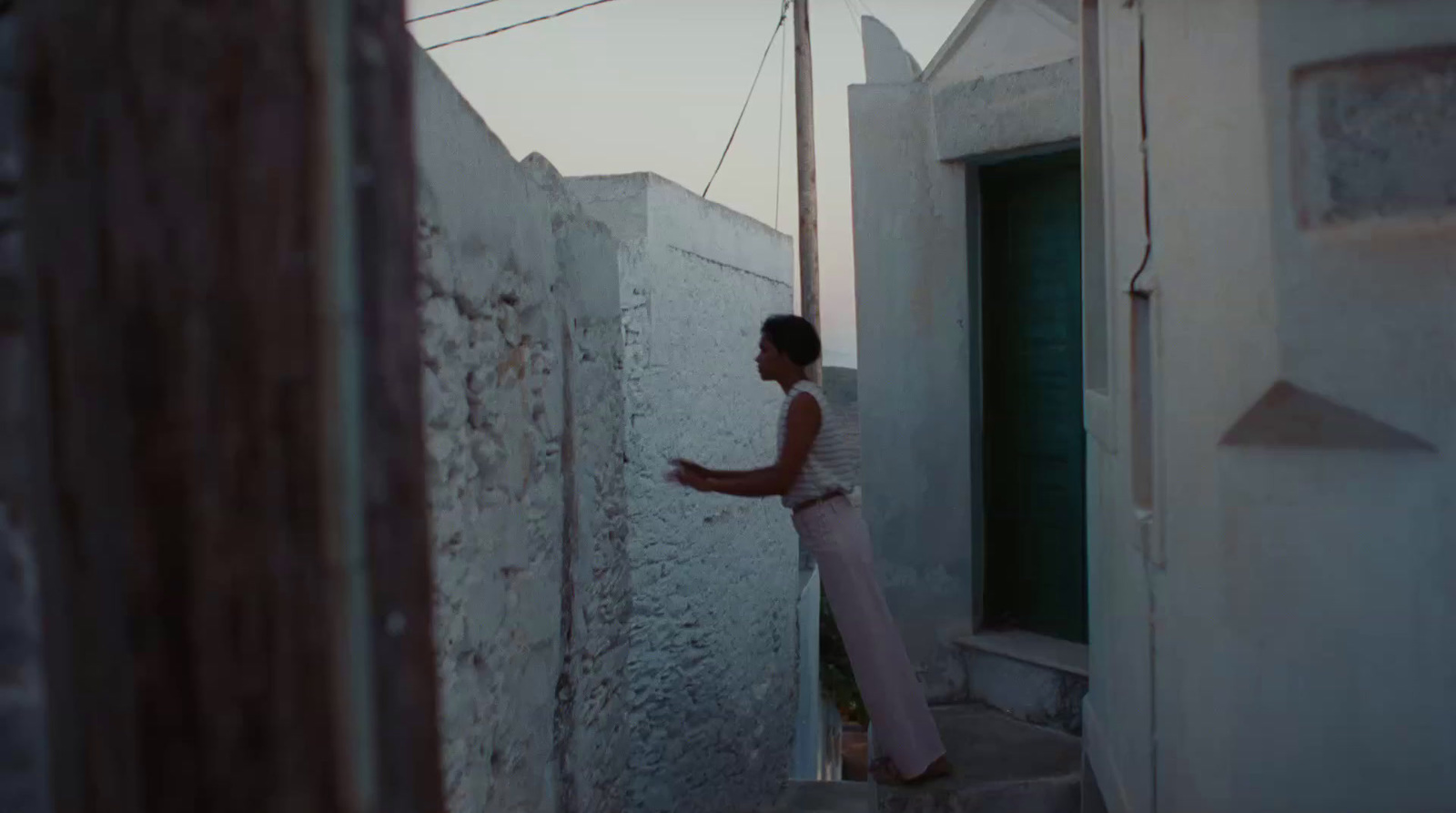 a woman standing in a narrow alley way