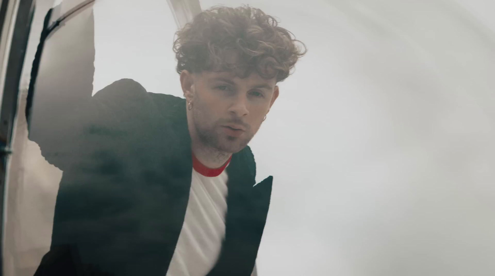 a man with curly hair wearing a suit and tie