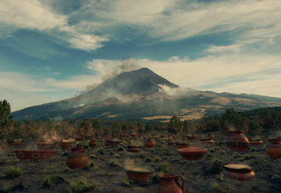 a large group of clay pots sitting on top of a dirt field