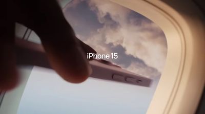 a hand holding a cell phone in front of an airplane window