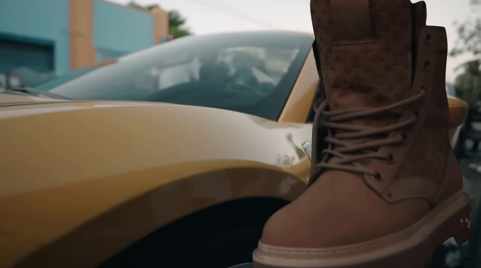 a close up of a person's boots in front of a car