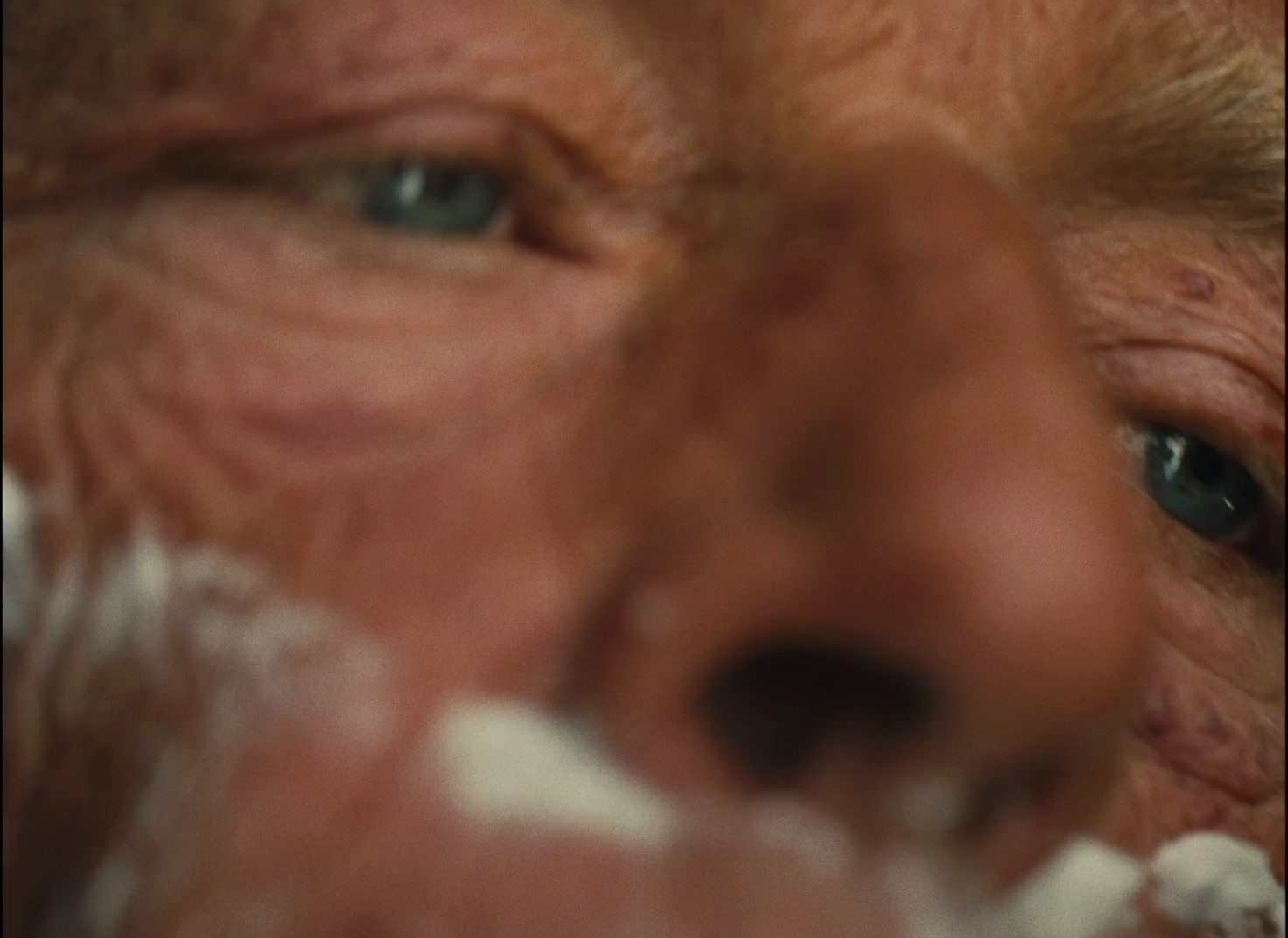 a close up of a man's face with blue eyes