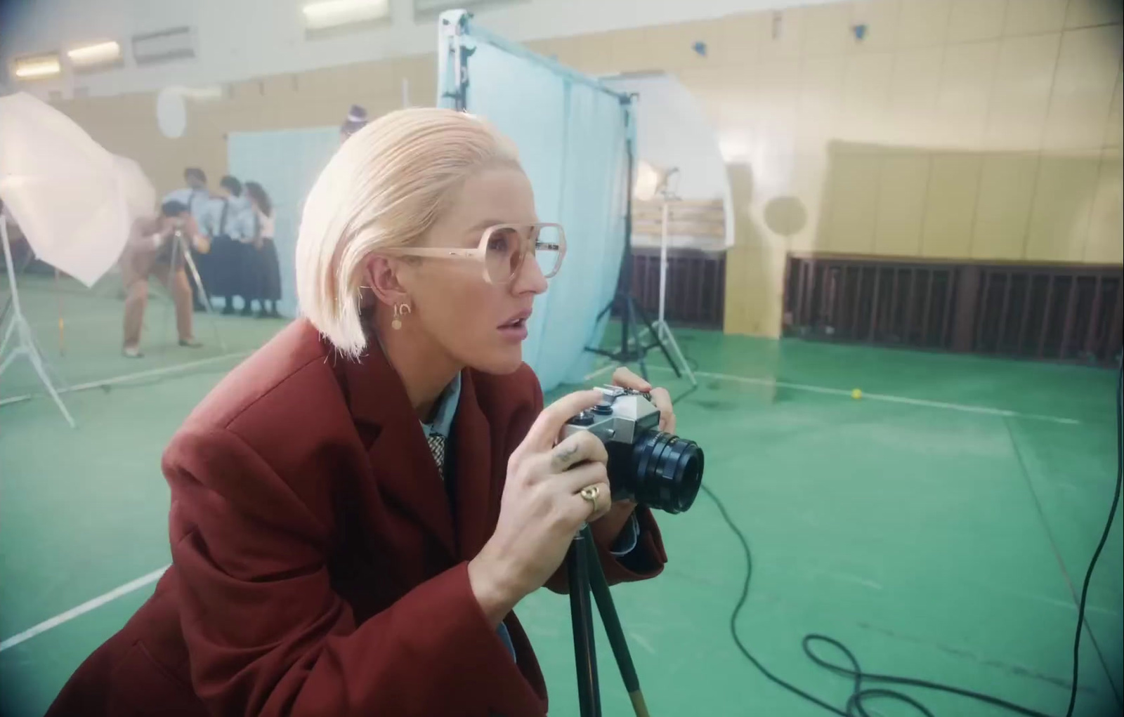 a woman in a red jacket is holding a camera