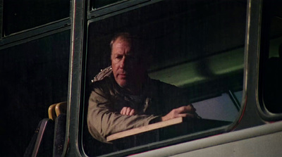 a man looking out the window of a bus