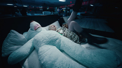 a person laying on a bed with a large stuffed animal