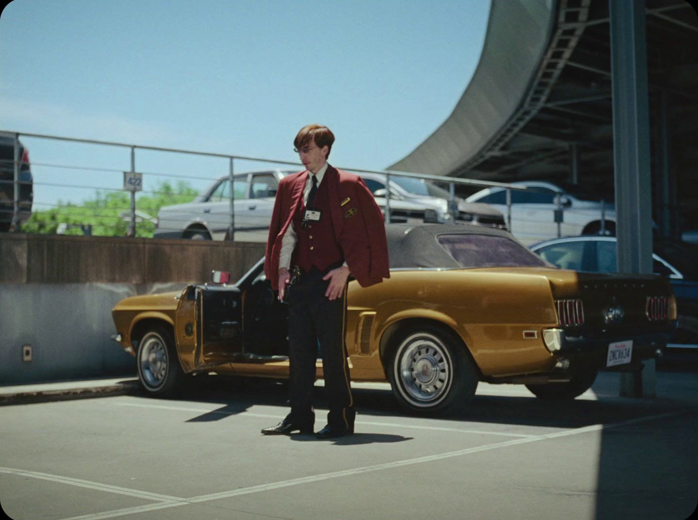 a man standing in front of a car in a parking lot