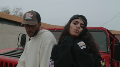 a man and a woman standing in front of a red truck