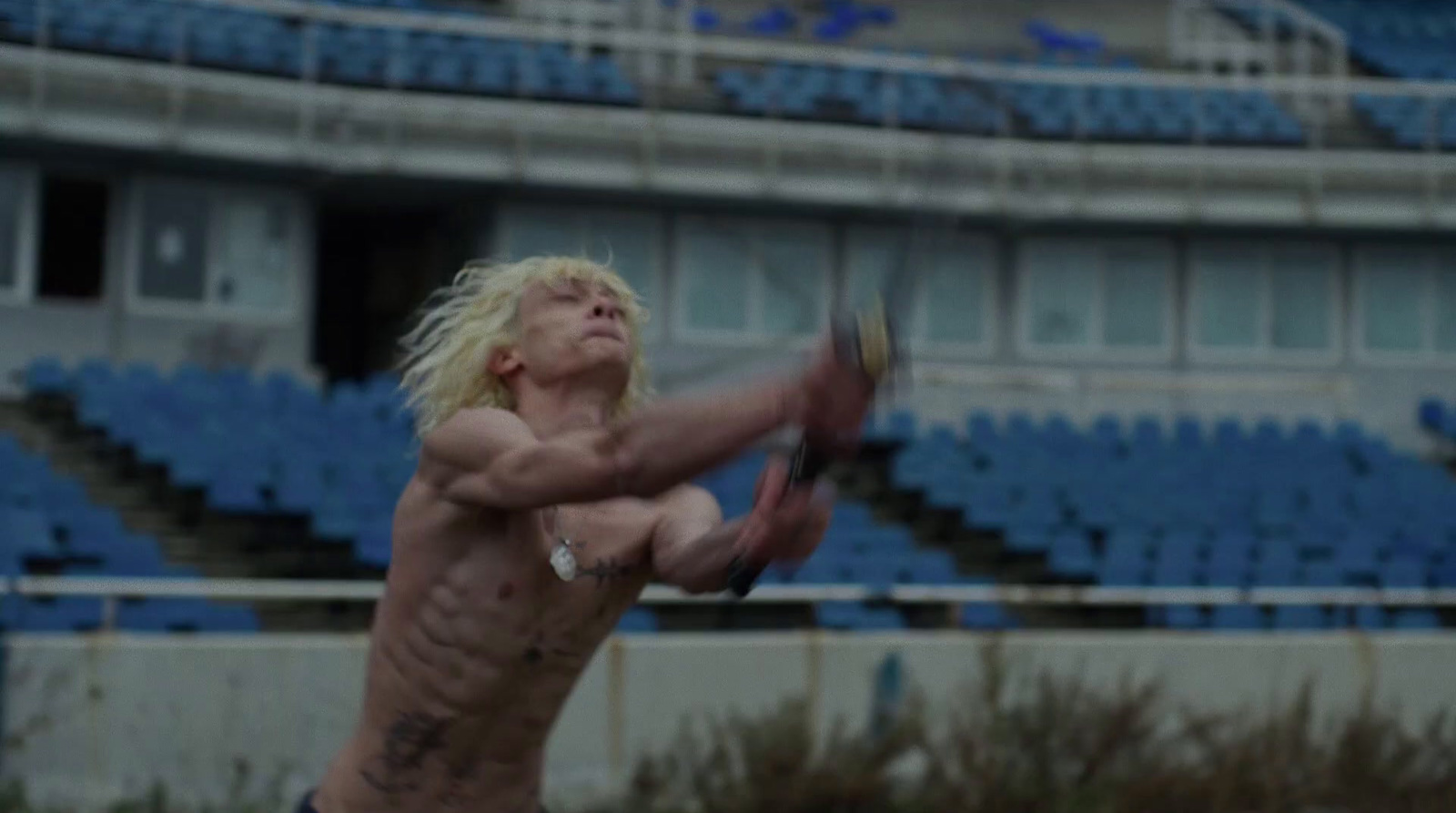 a shirtless man is playing tennis in a stadium