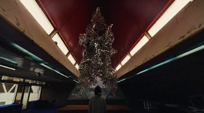 a person standing in front of a christmas tree