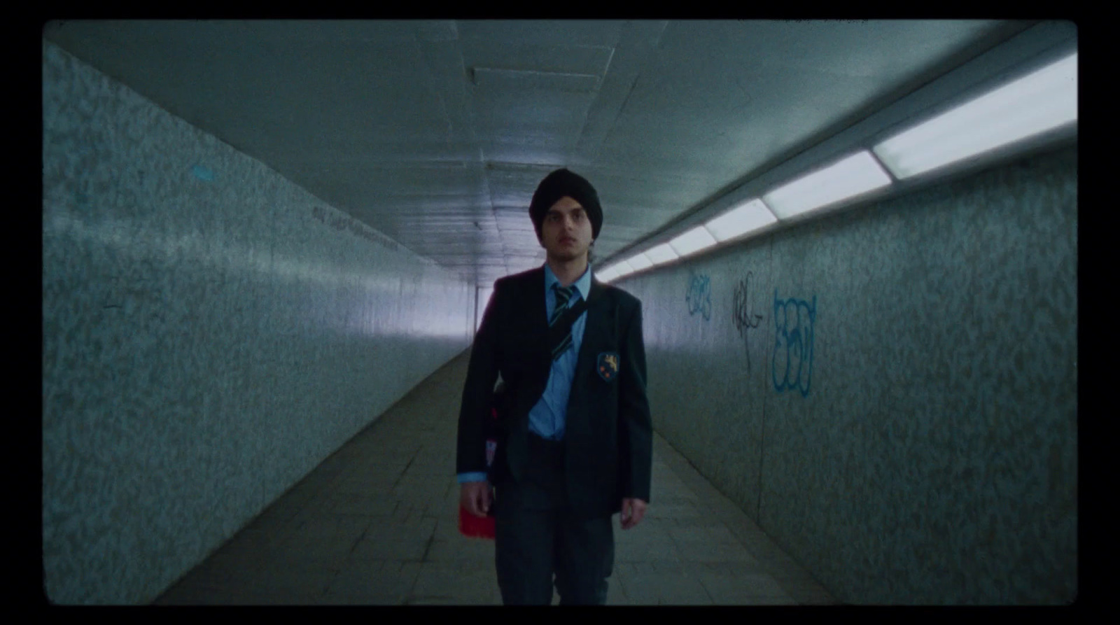 a man in a suit and tie walking down a hallway