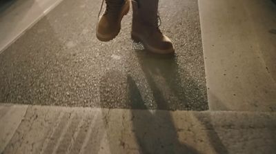 a person walking down a sidewalk with their shoes on