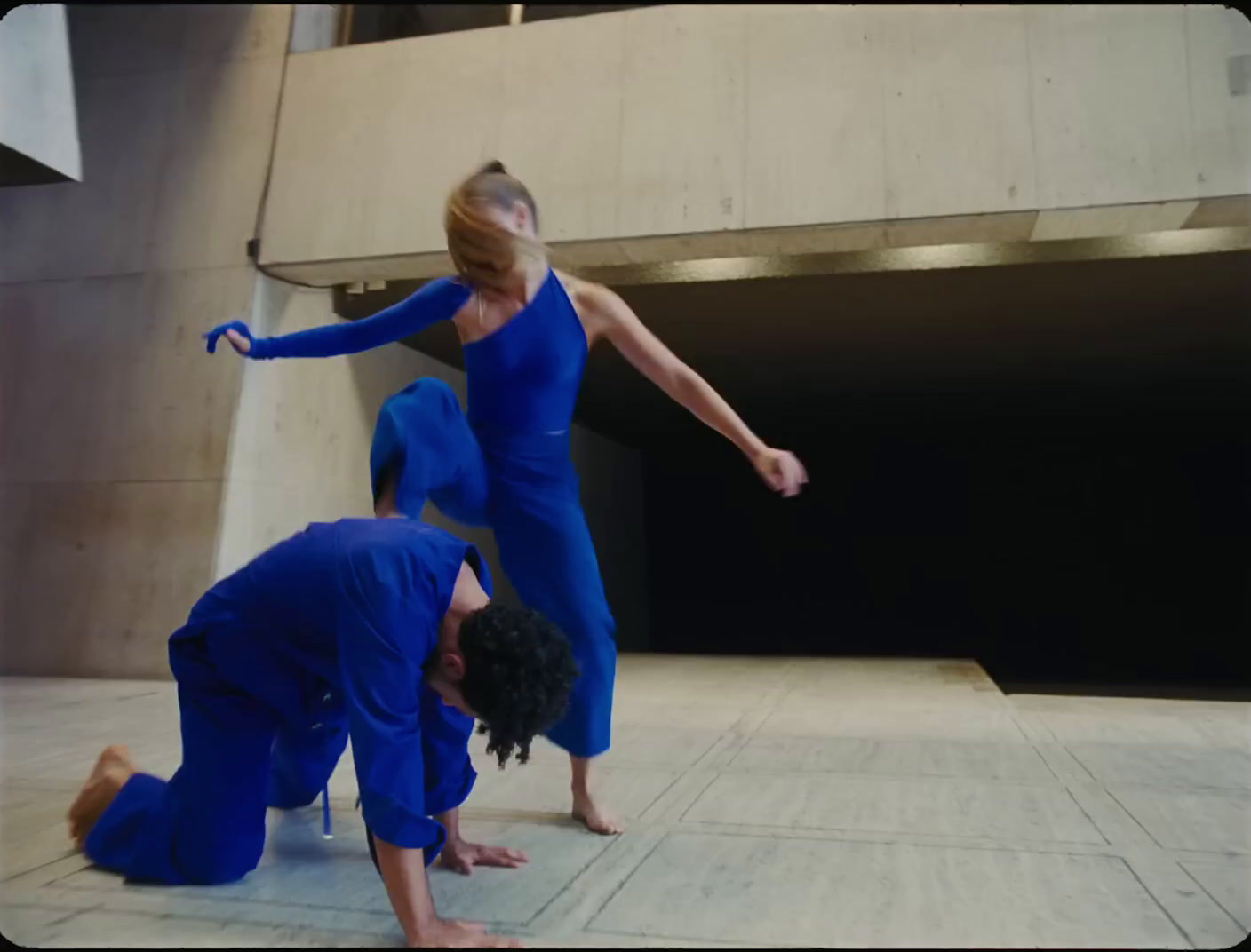 two people doing a handstand on the ground