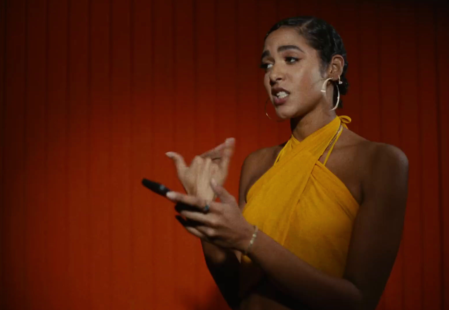 a woman in a yellow dress holding a cell phone