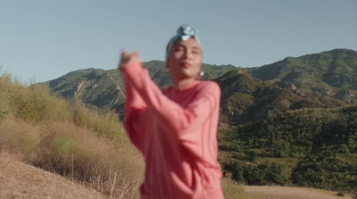 a woman in a pink dress is throwing a frisbee