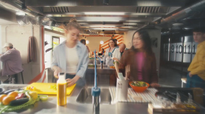 a group of people standing around a kitchen