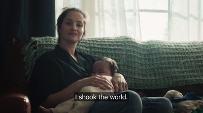 a woman sitting on a couch holding a baby