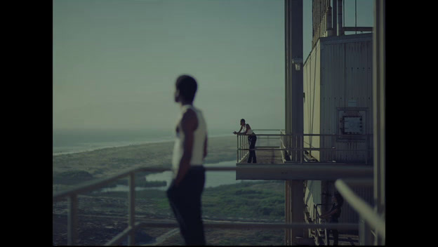 a man standing on top of a balcony next to a tall building