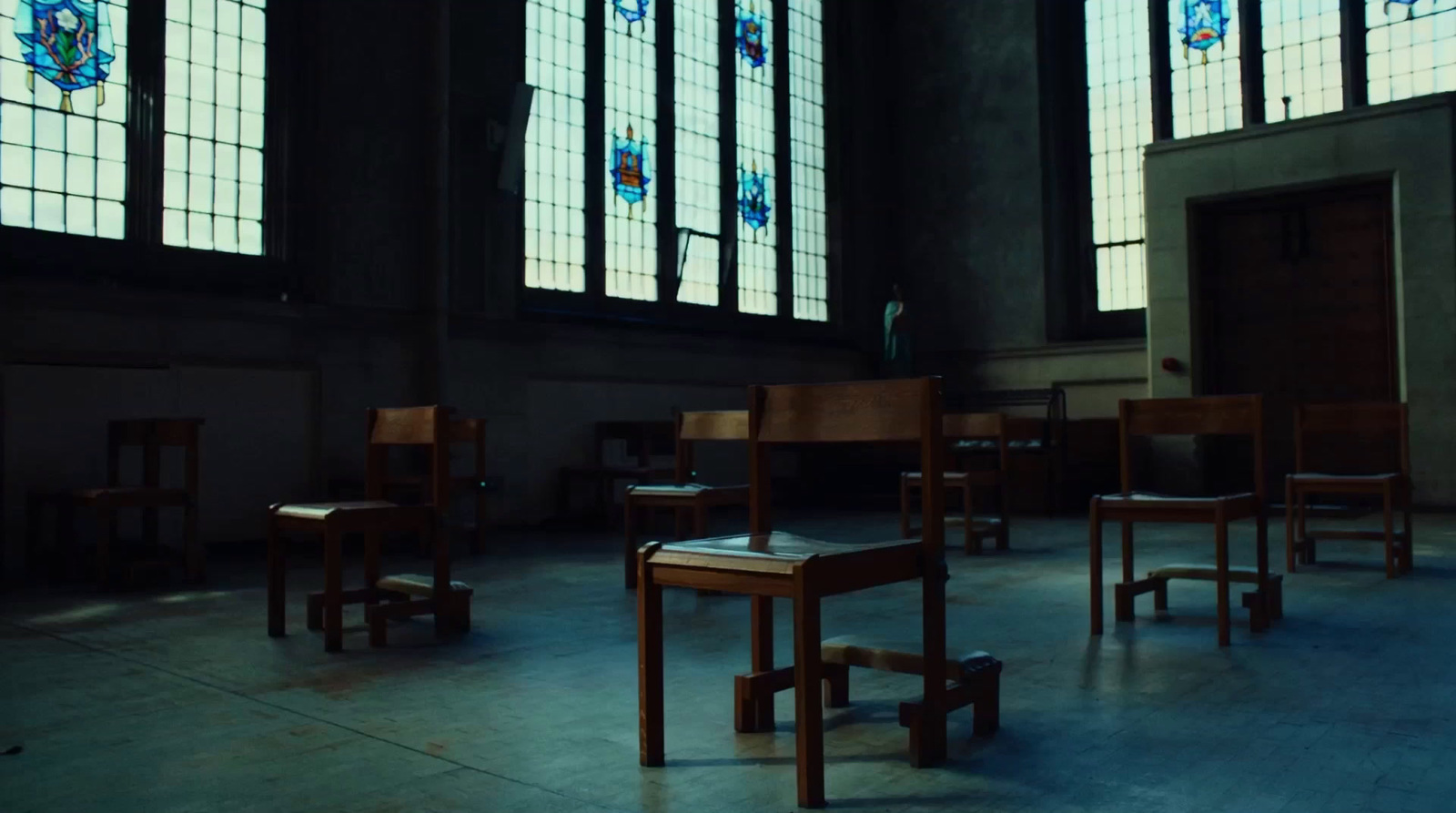 a room filled with lots of windows and wooden chairs