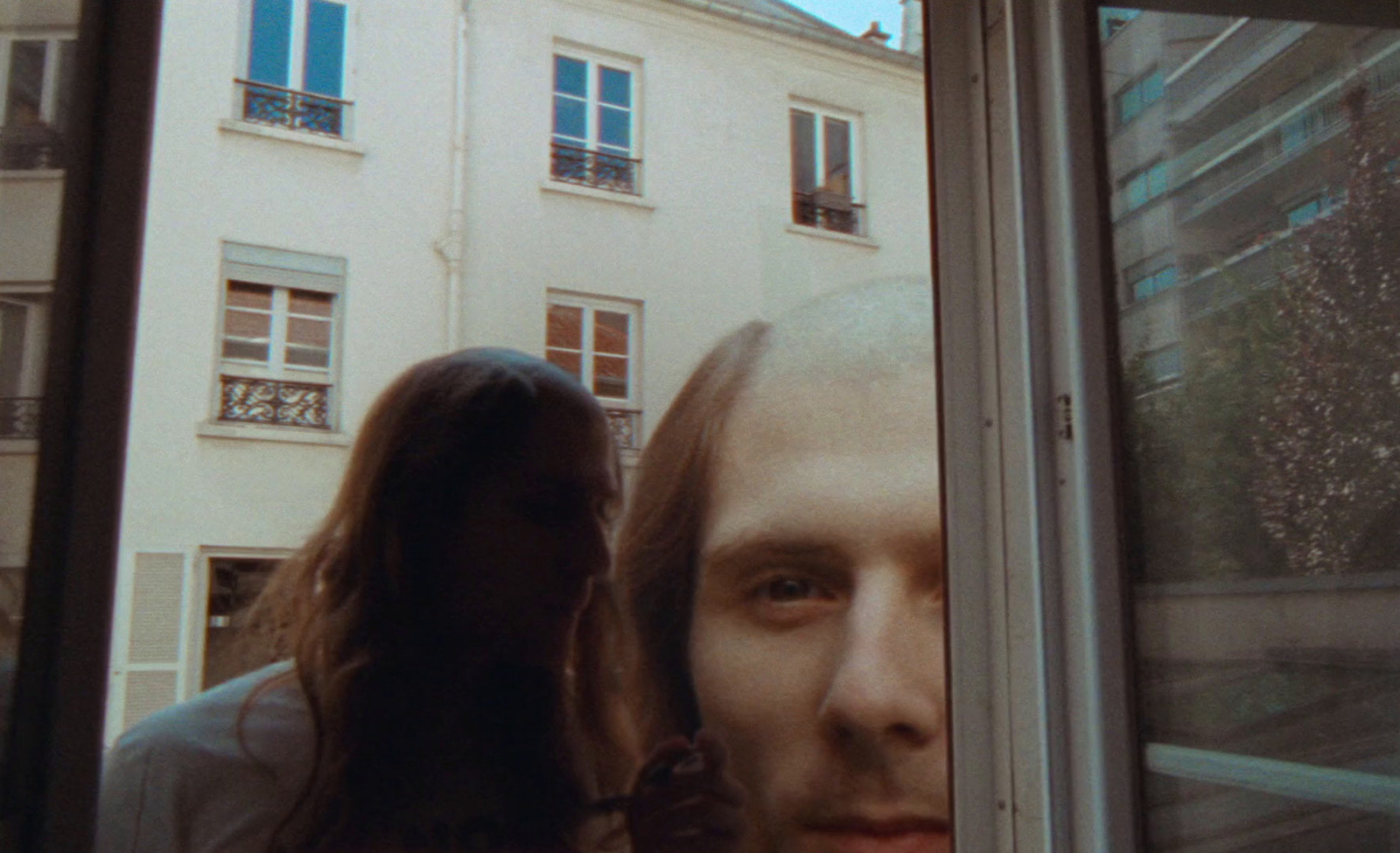 a man and a woman looking out a window