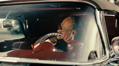 a man sitting in a car talking on a cell phone