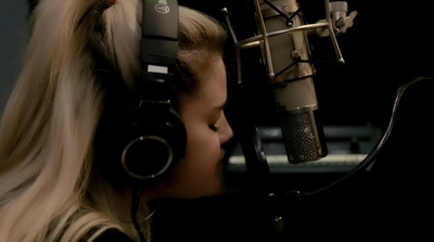 a young girl wearing headphones and listening to a microphone