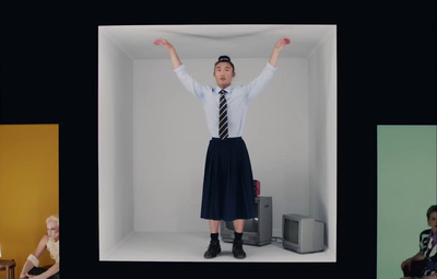 a woman in a skirt and tie standing in a room