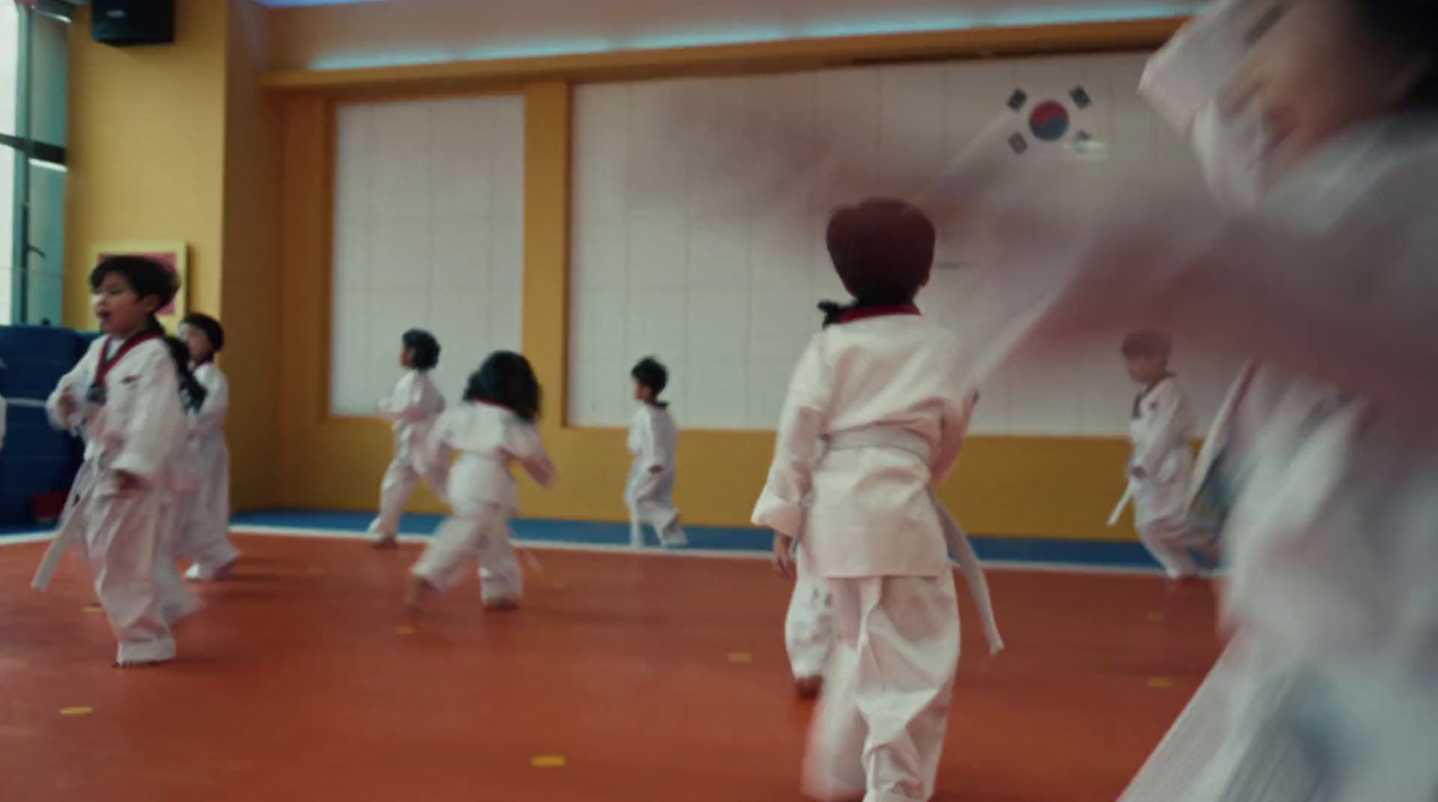 a group of kids in karate uniforms in a gym