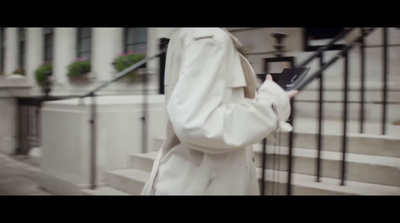 a woman in a white coat is standing on the steps