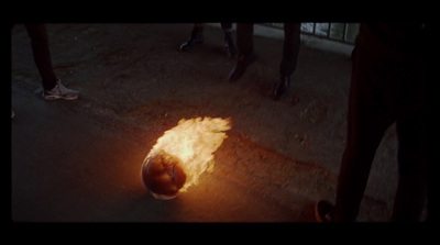 a ball of fire on the ground in front of a group of people