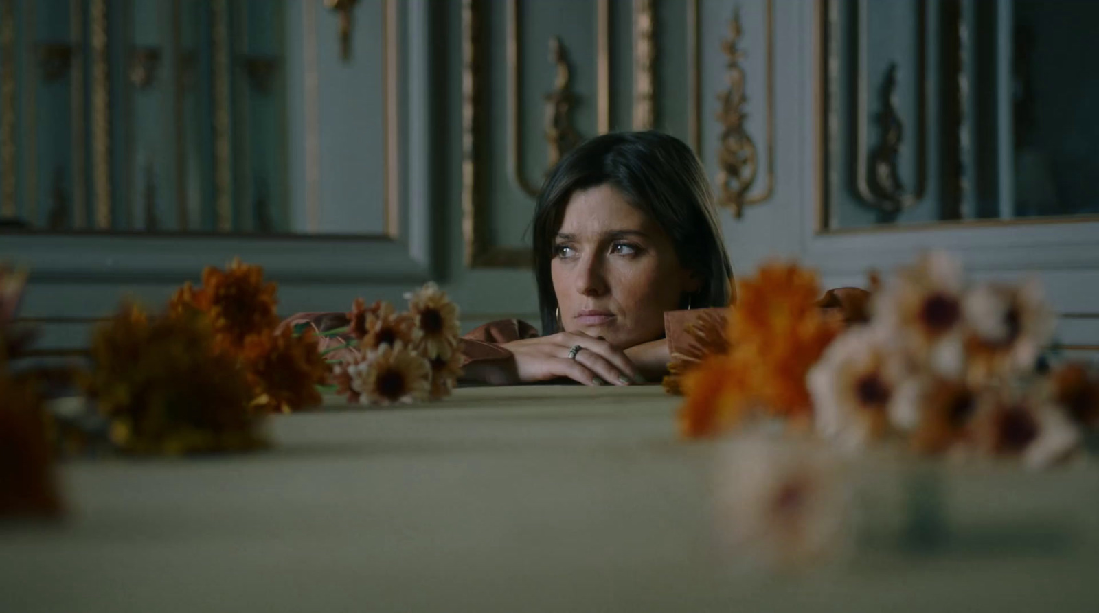 a woman sitting at a table with flowers in front of her