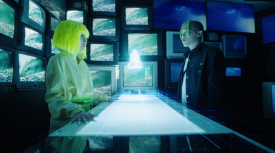 a man and a woman standing in front of a display of television screens