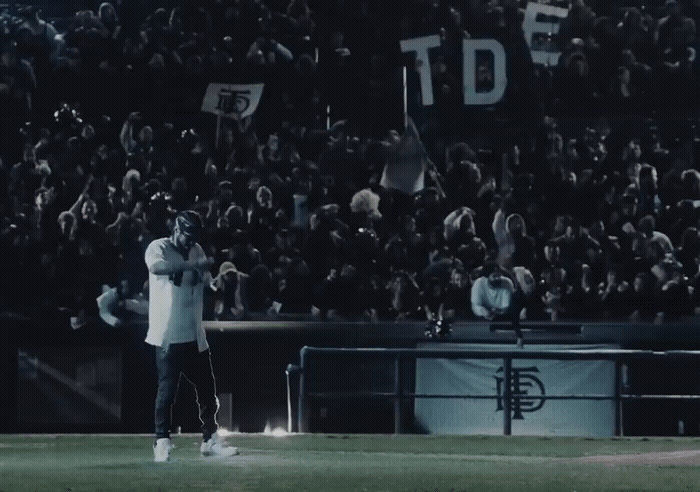 a man standing on top of a field in front of a crowd