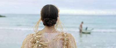 a woman with a braid in her hair standing on the beach